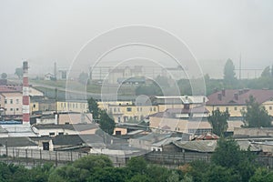 old abandoned factory building in the middle of a green forest. Panorama of the city with a view of factories and enterprises.