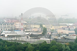 old abandoned factory building in the middle of a green forest. Panorama of the city with a view of factories and enterprises.