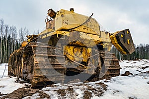 Old abandoned faulty construction bulldozer equipment. Disassembled crawler tractor at a construction site. Broken pipelayer