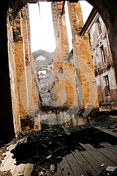 An old, abandoned and forgotten building of red  brick visas from the inside .