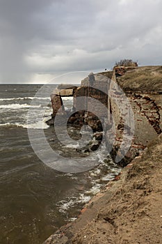 An old abandoned fortress on the shore. View from the cliff to the sea.