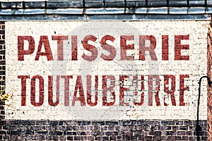 Old abandoned french bakery shop sign on a brick wall