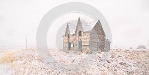 Old abandoned gable house homestead in blizzard on the yakima indian reservation