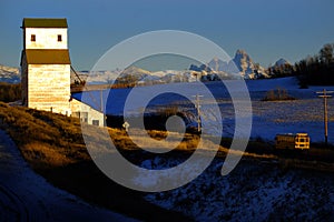 Old Abandoned Grainary Grainery Building with Tetons Teton Mount