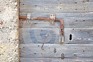 Old, abandoned, gray, wooden door with padlock