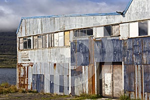 Old and abandoned harbor building on the fjord.