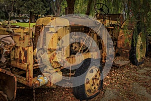 Old abandoned heavy equipment amongst trees in a rural setting