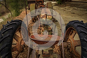 Old abandoned heavy equipment, tractor, amongst trees in a rural setting