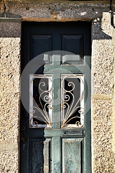 Old abandoned house facade with green wooden door