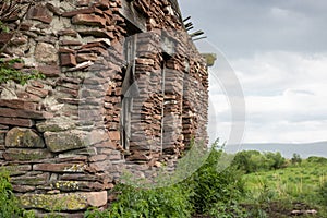 Old abandoned house made of natural brown stone. Architecture.