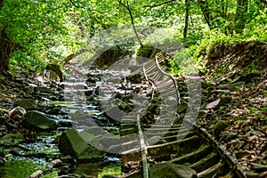 Old abandoned mining train rails in the dark forest
