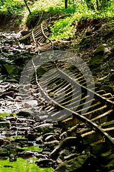 Old abandoned mining train rails in the dark forest