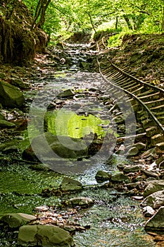 Old abandoned mining train rails in the dark forest