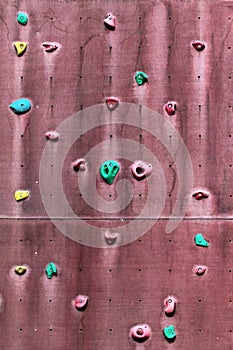 Old abandoned outdoor climbing wall with grips and holds