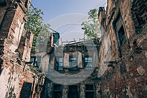 Old abandoned red brick house ruin, damaged by earthquake, war or other natural disaster, demolished decay debris