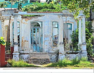 Old abandoned roofless house with blue door and windows in Havana, Cuba photo