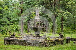 Old abandoned ruined fountain in overgrown park