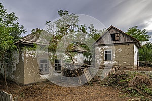 Old abandoned ruined house in dead village. Deserted and destroyed dwelling on farm yard. Neglected building countryside