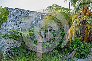 Old abandoned ruined traditional maldivian house made of corals on the street at the village at Landhoo island at Noonu atoll