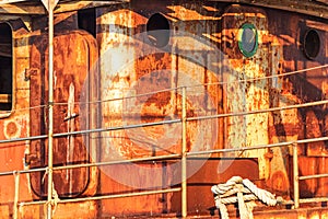 Old abandoned rusted ship moored to the pier in the seaport close up