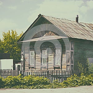 Old abandoned rustic wooden house with three windows on facade