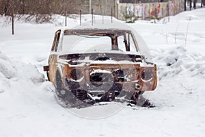 Old abandoned rusty car in snow in Russian