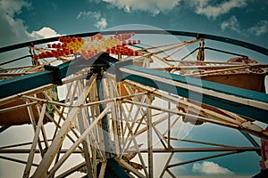 An Old abandoned rusty metal ferris wheel against blue sky. Detailed view of abandoned ferris wheel.