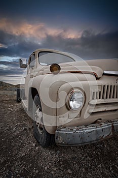 Old abandoned rusty truck with cloudy sky background