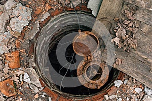 Old abandoned rusty water-supply brick mine, hatch, rusty water pipe