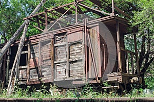 Old abandoned rusty wooden train and cargo wagon on the railway in the forest