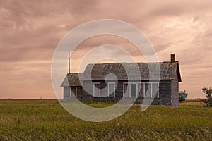 An old, abandoned school house sitting in the middle of the great plains