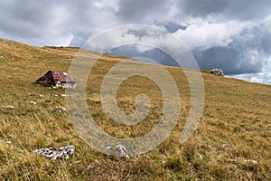 Old abandoned shepherd\'s hut in middle of pasture on slope of Vlasic mountain