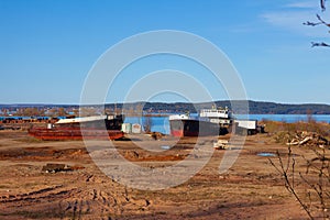 Old, abandoned ships in the port on a background of blue lake