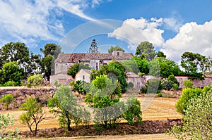 Old abandoned stone country house in Catalonia, surrounded by a meadow and trees