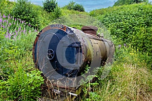 An old abandoned train tank car in the middle of the woods