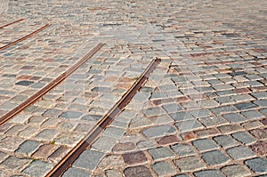 Old abandoned tram rails in city in stone pavement