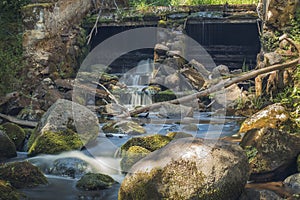 Old, abandoned water mill with water streams and little waterfalls