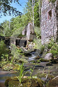 Old, abandoned water mill with water streams and little waterfalls