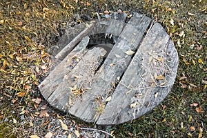 Old abandoned well with a broken wooden lid