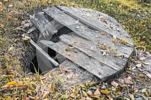 Old abandoned well with a broken wooden lid