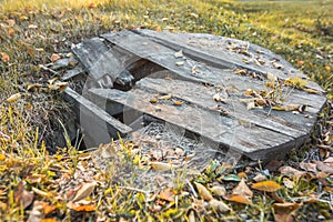 Old abandoned well with a broken wooden lid