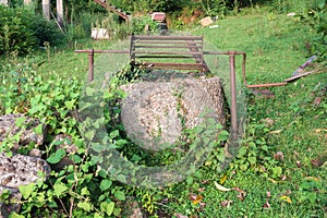 An old abandoned well in a field overgrown with ivy