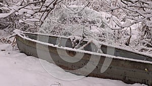 Old abandoned wooden boat on winter snow