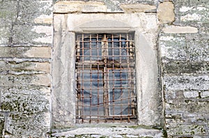 Old abandoned wooden box with glass of rusty metal bars in the concrete wall in a building of ancient architecture in Lviv