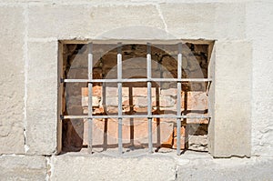 Old abandoned wooden box with glass of rusty metal bars in the concrete wall in a building of ancient architecture in Lviv