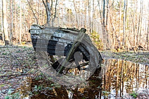 Old abandoned wooden fishing boat in the forest. Boat cemetery