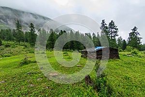 Old abandoned wooden house stands in the summer in the mountains of cloud