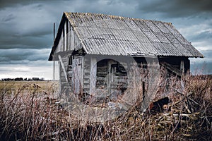 Old abandoned wooden house in a view of dark cloudy sky