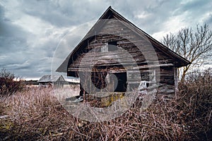 Old abandoned wooden house in a view of dark cloudy sky