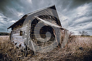 Old abandoned wooden house in a view of dark cloudy sky